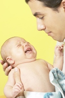 Father holding crying baby photo